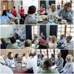 Team coaching session with a group of professionals engaged in presentations and discussions in a conference room setting.