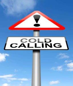 Warning sign with an exclamation mark and a "Cold Calling" sign below against a blue sky background.