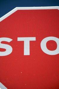 Close-up view of a red stop sign with the letters "STO" visible.