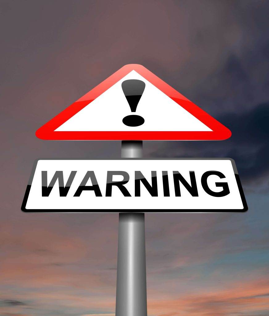 A warning sign with an exclamation mark against a cloudy sky background.
