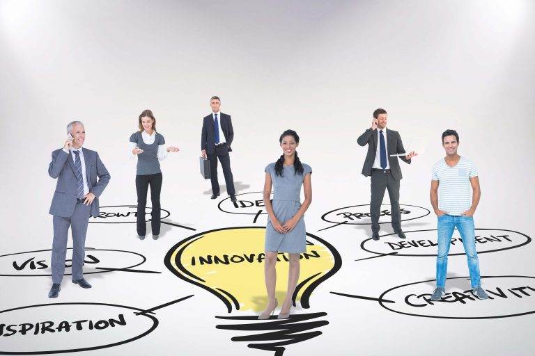 Diverse group of six professionals standing on a giant light bulb sketch labeled "innovation" with related words like "vision" and "development.