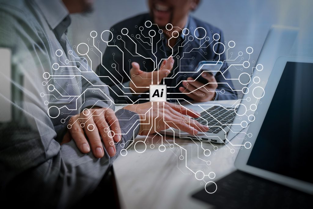 Two people discuss AI tools for businesses while using a laptop and smartphone, with digital circuit graphics overlaying the image.