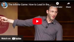 Speaker presenting "The Infinite Game" concept on leadership, gesturing on stage, captured in a YouTube video thumbnail.