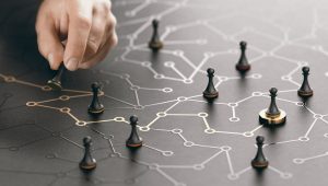 Hand moving a chess piece on a network path, symbolizing strategic career planning and guidance services.