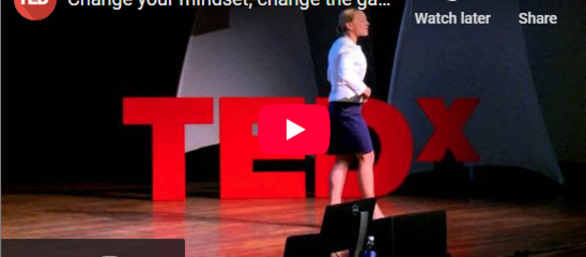 Speaker in white shirt on stage with TEDx sign, giving a talk titled "Change your mindset, change the game" on YouTube.