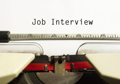 Typewriter with "Job Interview" text; symbolizes career coaching focus on interview skills.