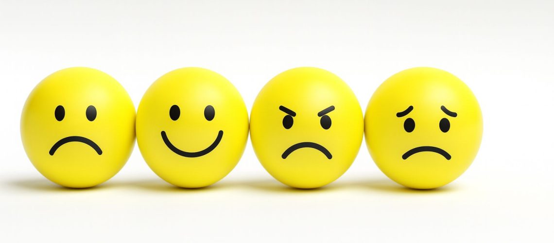 Four yellow emoji balls displaying a kaleidoscope of emotions: happy, sad, angry, and confused.